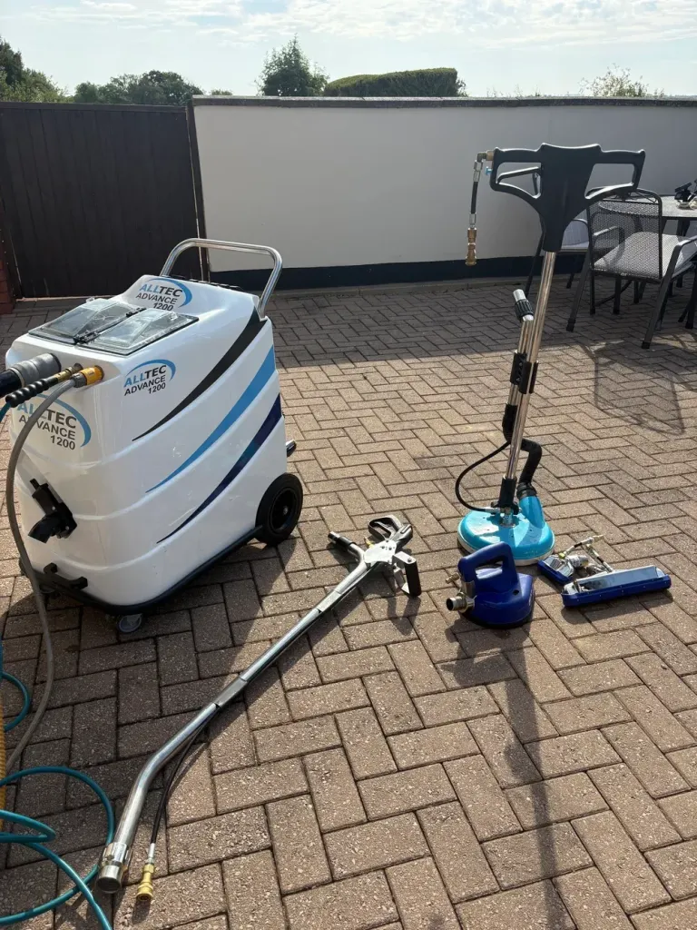 Alltec Advance 1200 extraction machine with a spinner tile-cleaning tool, wand and hand tools laid out on a block-paved patio.