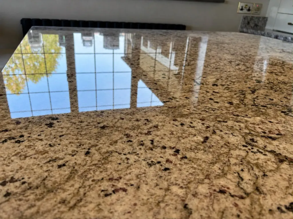 Gold granite worktop reflecting a window after polishing